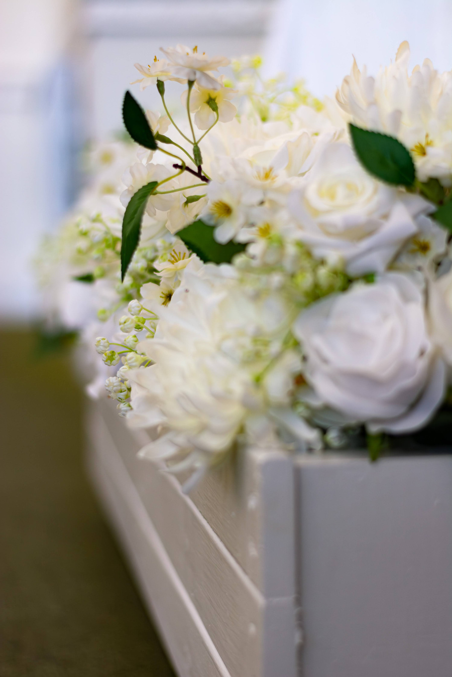 a luxurious white wedding flower arrangement in a wooden box
